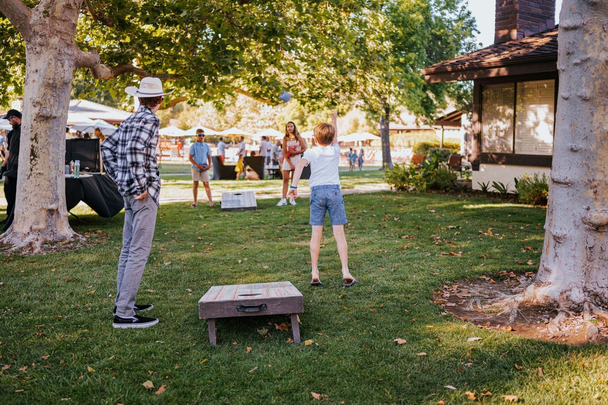 Family playing lawn games, cornhole.
